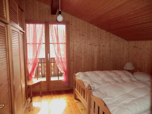 a bedroom with a bed in a room with windows at Sonja in Schwarzsee