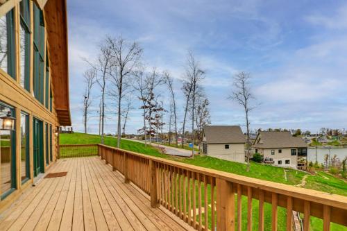 a wooden deck with a view of a house at Large Deck and Shared Dock Cabin on Kentucky Lake! in Gilbertsville