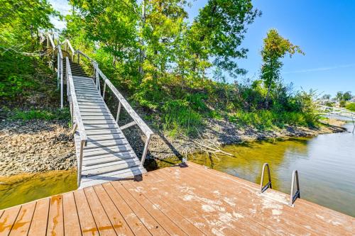a wooden walkway leading to a bridge over a river at Large Deck and Shared Dock Cabin on Kentucky Lake! in Gilbertsville