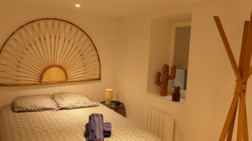 una camera da letto con un letto e un grande ventilatore a muro di CosyRouen Jacuzzi Parking gratuit a Rouen
