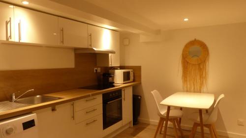 une petite cuisine avec un évier et un micro-ondes dans l'établissement CosyRouen Jacuzzi Parking gratuit, à Rouen