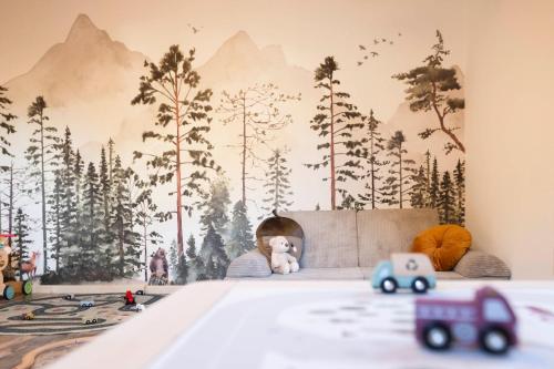 a bedroom with a mural of trees on the wall at Hotel Stubaierhof in Neustift im Stubaital