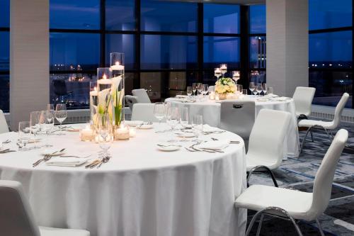 a group of tables with white table cloths and chairs at Le Méridien Chicago - Oakbrook Center in Oak Brook