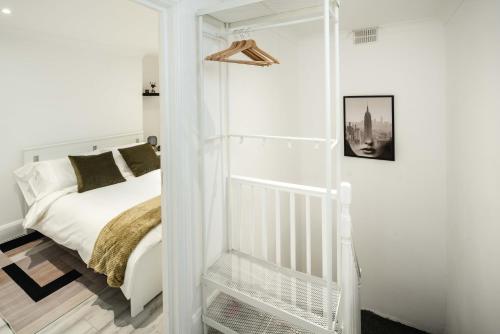 a white bedroom with a bed and a white closet at Modern 2BR Flat - 7 Min to WhiteChapel Station in London