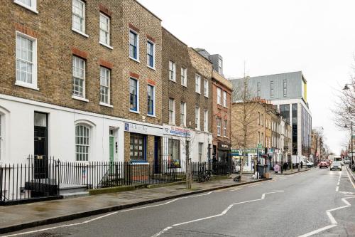 an empty city street with buildings and a fence at Modern 2BR Flat - 7 Min to WhiteChapel Station in London