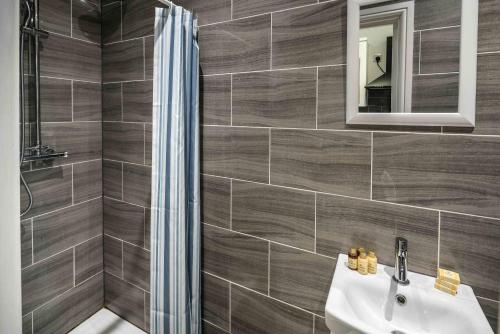 a bathroom with a sink and a mirror at Modern 2BR Flat - 7 Min to WhiteChapel Station in London