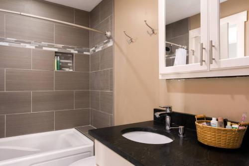 a bathroom with a sink and a bath tub at Back Alley Apartment, Walk Downtown And Duke in Durham