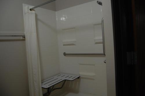 a small white bathroom with a bench in it at Quality Inn Homestead Park in Billings