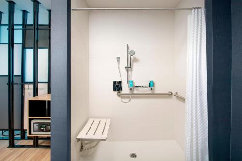 a bathroom with a bath tub with a bench at Aloft Dublin-Pleasanton in Dublin