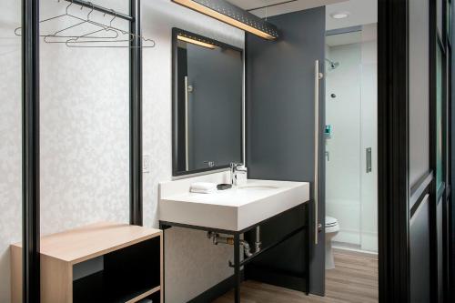 a bathroom with a sink and a mirror at Aloft Dublin-Pleasanton in Dublin