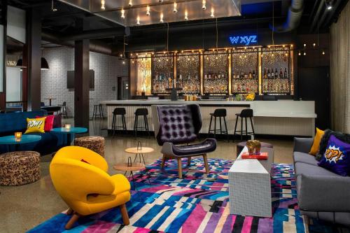 a lobby with a bar with chairs and tables at Aloft Dublin-Pleasanton in Dublin