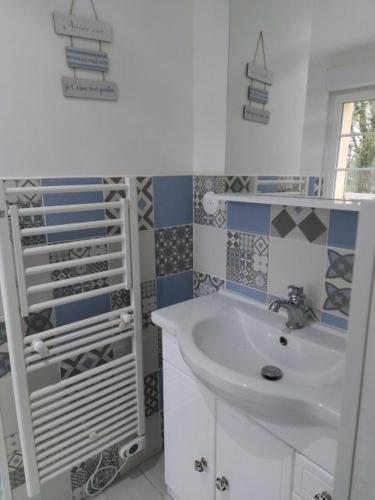a white bathroom with a sink and a shower at Les nids de la Baie in Favières
