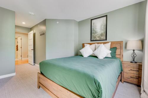 a bedroom with a large bed with a green comforter at Close to Beaver Creek and Vail Cozy Edwards Condo! in Edwards