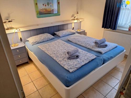 a bedroom with two beds with towels on them at Luv und Lee Ferienwohnung Westerhever in Juist
