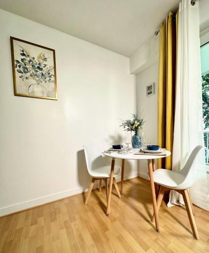 une salle à manger blanche avec une table et des chaises dans l'établissement Le Bleu Soleil - à 2 min du métro - 7 min de Paris, à Maisons-Alfort