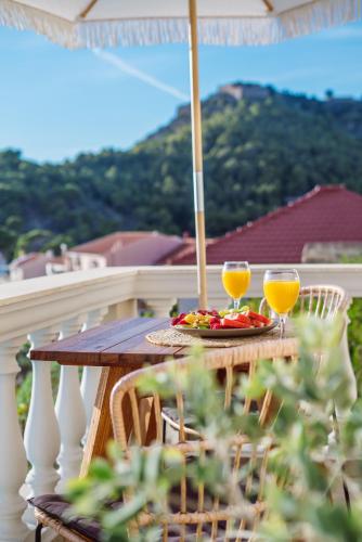 a table on a balcony with two glasses of orange juice at Kanakis Apartments in Asos