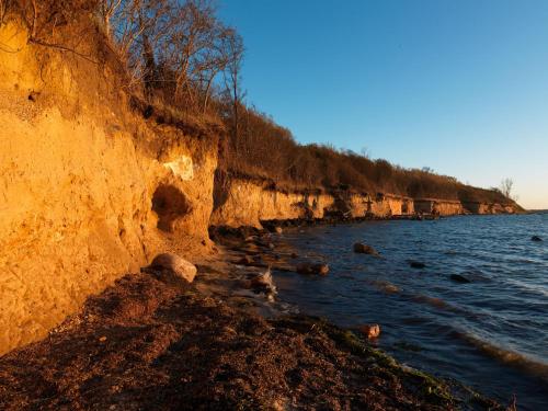 a beach with rocks and water and a cliff at Appartements Am Reiterhof Seepferdchen in Timmendorf