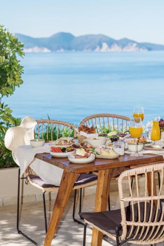 a wooden table with food and glasses of wine at Kanakis Apartments in Asos
