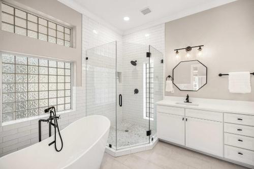 Un baño blanco con bañera y ducha. en Gulf Coast Retreat with Pool 1 Mile to Beach, en Santa Rosa Beach