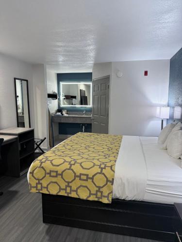 a bedroom with a bed and a desk and a sink at Baymont by Wyndham Grenada in Grenada