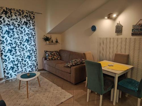 ein Wohnzimmer mit Sofa und Tisch in der Unterkunft Casa Mia 2 Porto in Herceg-Novi