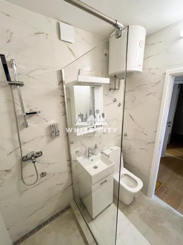 a white bathroom with a toilet and a sink at WATEREFRONT Apartments - Belgrade in Belgrade