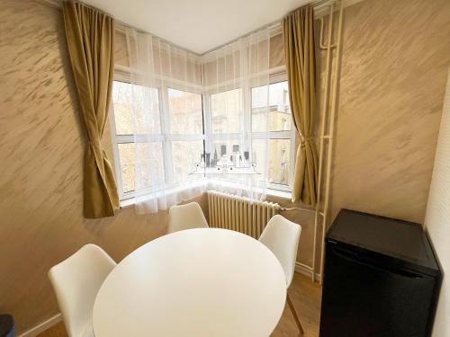a white table and chairs in a room with a window at WATEREFRONT Apartments - Belgrade in Belgrade