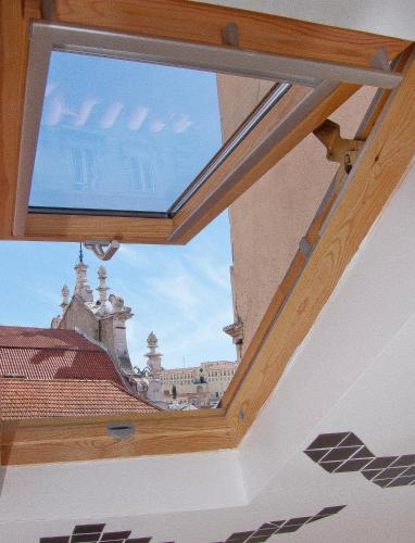 a window in a roof with a view of a building at Lisbon Story Guesthouse in Lisbon