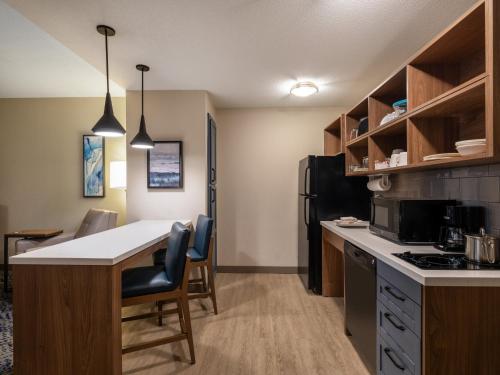 a kitchen with a counter and a table and chairs at Candlewood Suites Manassas by IHG in Manassas