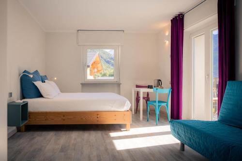 une chambre avec un lit, une fenêtre et une chaise dans l'établissement l'Oura B&B, à Challand Saint Anselme