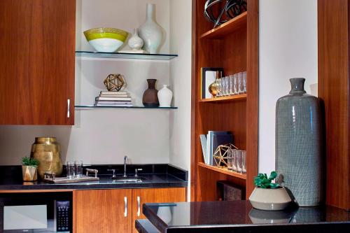 a kitchen with wooden cabinets and a counter with vases at Renaissance Atlanta Midtown Hotel in Atlanta