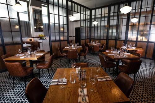 a restaurant with wooden tables and chairs and windows at Renaissance Atlanta Midtown Hotel in Atlanta