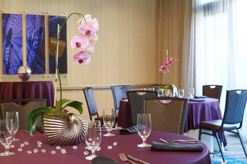 a dining room with purple tables with glasses and flowers at Renaissance Atlanta Midtown Hotel in Atlanta