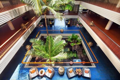 an overhead view of a hotel swimming pool with palm trees at Mauna Kea Beach Hotel, Autograph Collection in Hapuna Beach