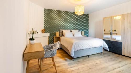 une chambre avec un lit, une table et un bureau dans l'établissement Gîte 21 route de saumur, à Parnay