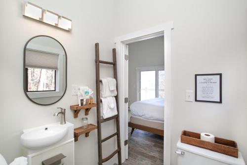 une salle de bain avec un lavabo, un miroir et un lit dans l'établissement Peaceful Heights with Cozy Decks and Smart TV, à Townsend