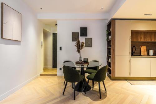 une salle à manger avec une table en verre et des chaises vertes dans l'établissement Petit joyau dans le Vieux Nice, à Nice