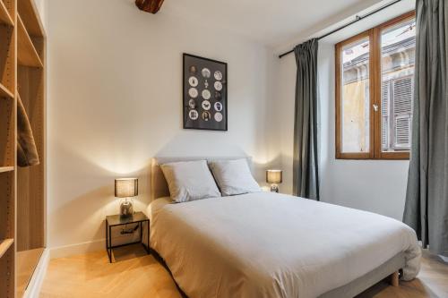 une chambre avec un lit blanc et une fenêtre dans l'établissement Petit joyau dans le Vieux Nice, à Nice