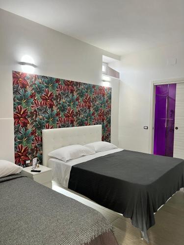 a bedroom with a large bed and a colorful wall at Villa Delle Rose in Naples