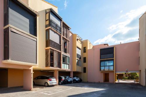 Une rangée de bâtiments avec des voitures garées dans un parking dans l'établissement SP350-188 Appartement 2 pièces cabine SAINT PIERRE LA MER, à Saint Pierre La Mer