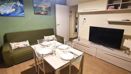 a living room with a dining table and a television at Lungomare Urban in Pescara