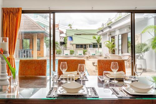a dining room with a table and chairs and a large window at Luxury 4BR Villa with Pool & Ocean Views on Patong in Patong Beach