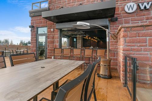 a wooden table and chairs in front of a brick building at Cobblestone Hotel & Suites - Lynden in Lynden