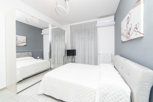 a white bedroom with two beds and a mirror at Luxury Seaview Apartment with Parking in Salerno City Center - Maison Dorotea in Salerno