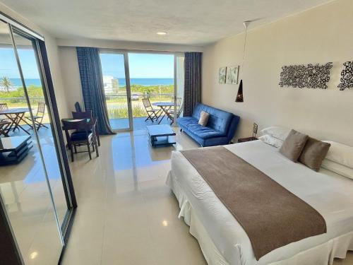 a bedroom with a large bed and a living room at Zen Boutique Apart Hotel in La Paloma