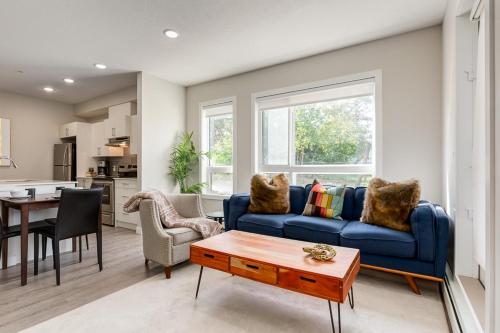 a living room with a blue couch and a table at Inner City Apartment, Pet Friendly, Free Underground Parking in Calgary