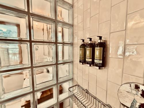 a bathroom with two bottles of alcohol on the wall at SEIN Boutique Suites - ADULTS ONLY in Gosau