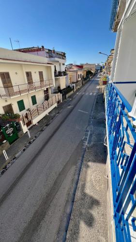 an empty street with a blue fence next to a building at Casa vacanza Lui & Giò in Trecase