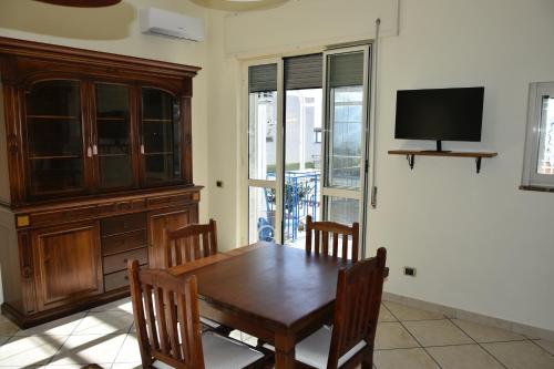 a dining room with a wooden table and a tv at Casa vacanza Lui & Giò in Trecase