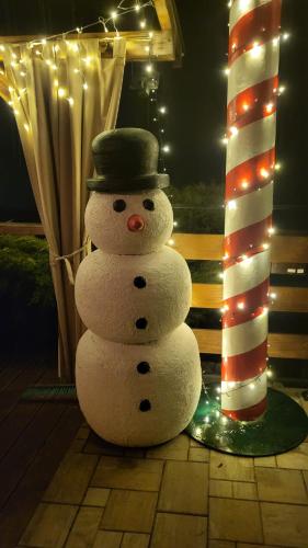 a snowman with a hat sitting on a patio at Willa Sulimówka - Noclegi Zakliczyn dom basen bania sauna SPA in Zakliczyn
